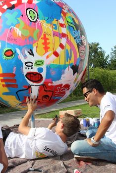 Kinder arbeiten mit Künstler Gael Froget am Fußball-Kunstwerk.